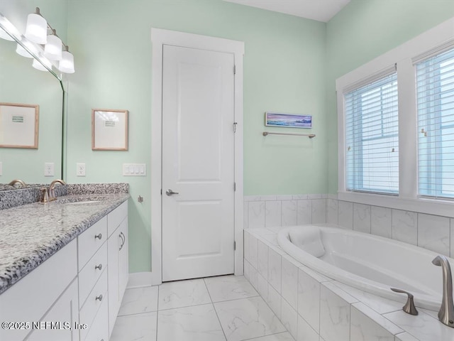 bathroom featuring vanity and tiled tub