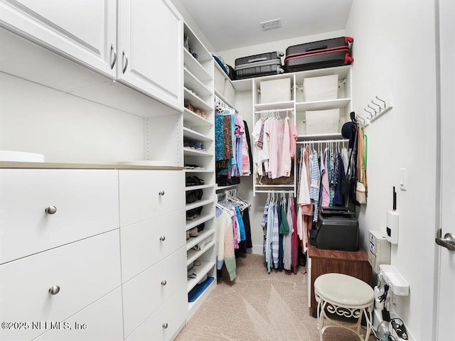 walk in closet featuring light colored carpet