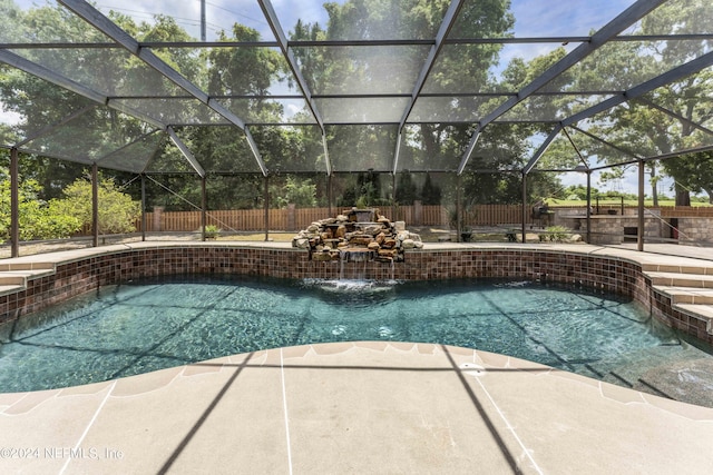 view of swimming pool with pool water feature, glass enclosure, and a patio