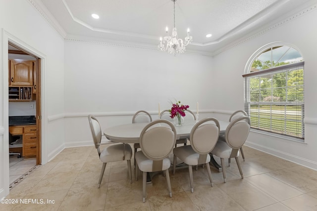 dining space with a notable chandelier, light tile patterned flooring, ornamental molding, and a tray ceiling