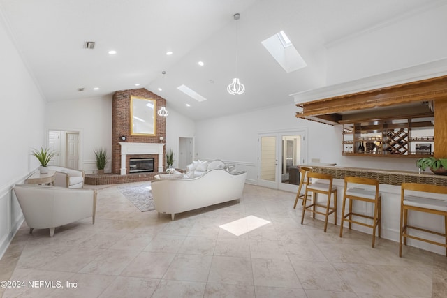 living room with a skylight, french doors, high vaulted ceiling, and a brick fireplace