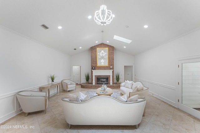 living room featuring vaulted ceiling with skylight, ornamental molding, a notable chandelier, and a brick fireplace