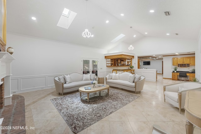 living room with french doors, a skylight, ornamental molding, high vaulted ceiling, and a fireplace