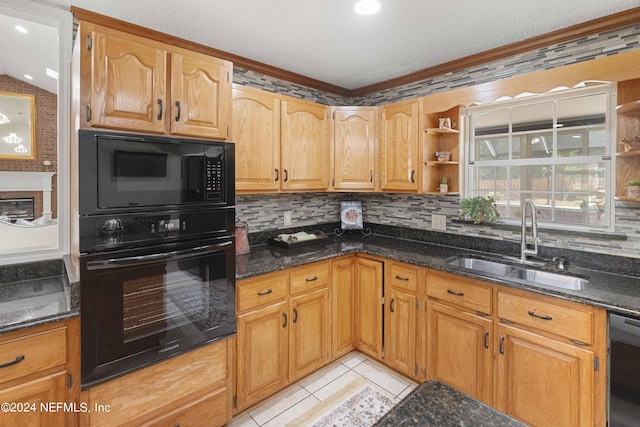 kitchen featuring black appliances, light tile patterned floors, sink, and dark stone counters