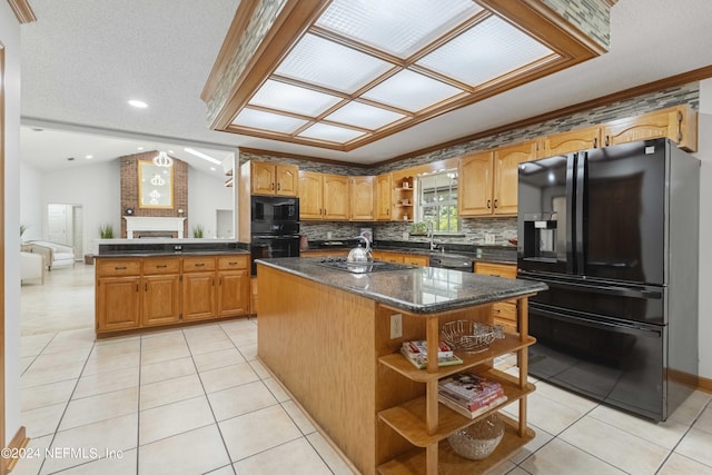 kitchen with light tile patterned flooring, lofted ceiling, backsplash, black appliances, and a kitchen island