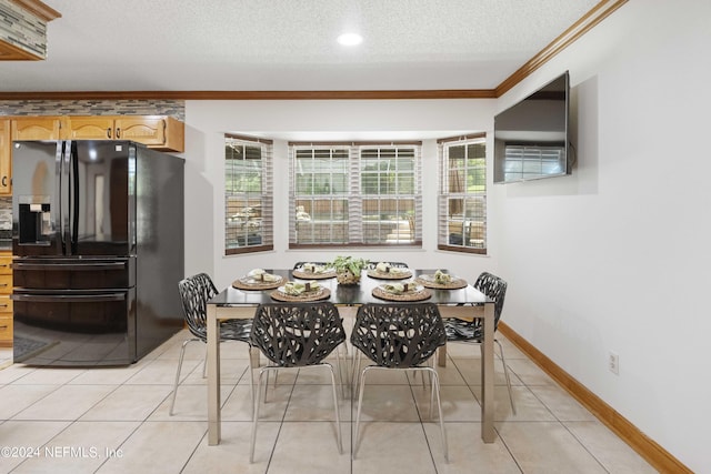 tiled dining room with a textured ceiling and ornamental molding