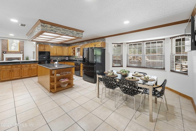 kitchen with a center island, black appliances, ornamental molding, a textured ceiling, and light tile patterned flooring