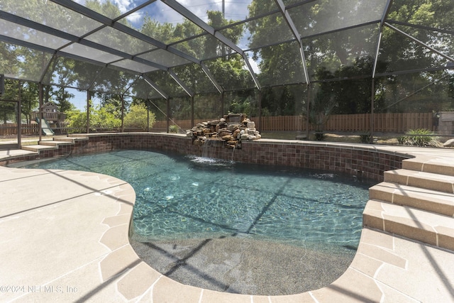 view of swimming pool with pool water feature, glass enclosure, a playground, and a patio