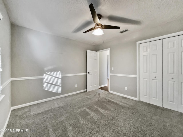 unfurnished bedroom featuring a textured ceiling, carpet floors, a closet, and ceiling fan