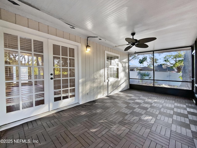 unfurnished sunroom featuring ceiling fan