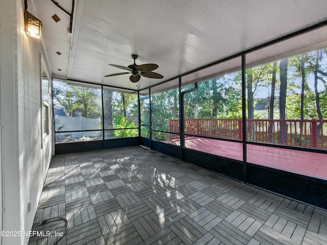 unfurnished sunroom with ceiling fan