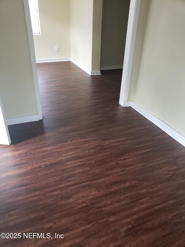 unfurnished room with dark hardwood / wood-style flooring