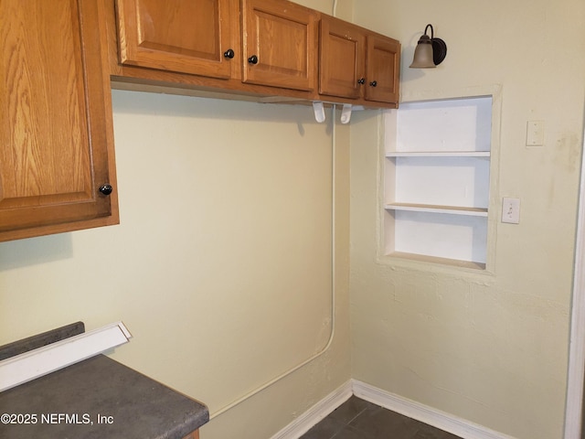 laundry room featuring dark tile patterned flooring