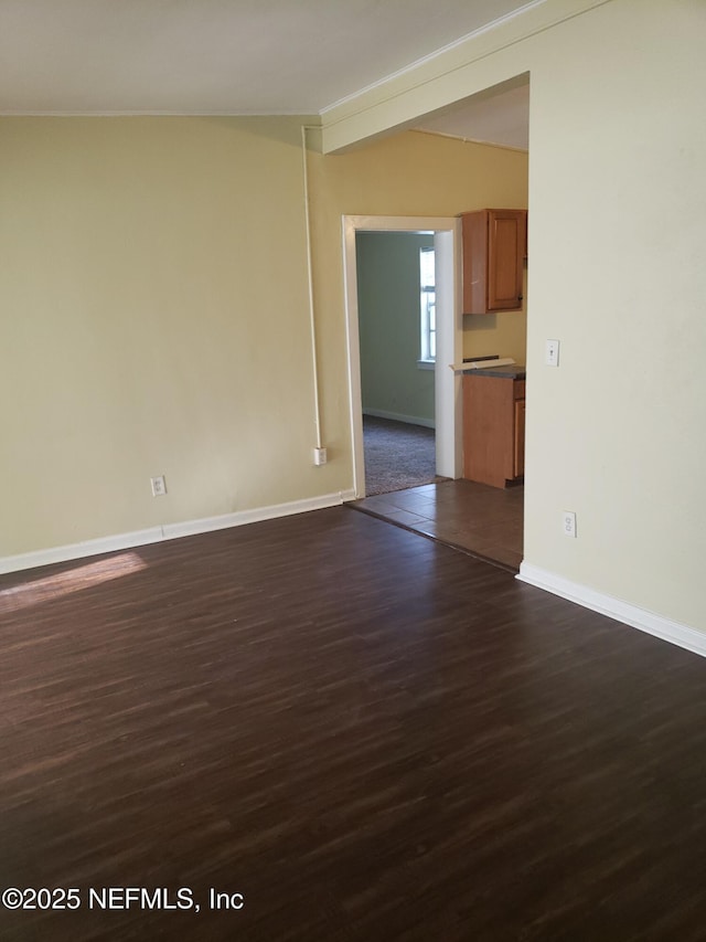 unfurnished room with dark wood-type flooring