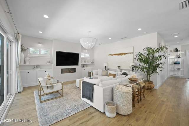 living room featuring light hardwood / wood-style flooring and a notable chandelier