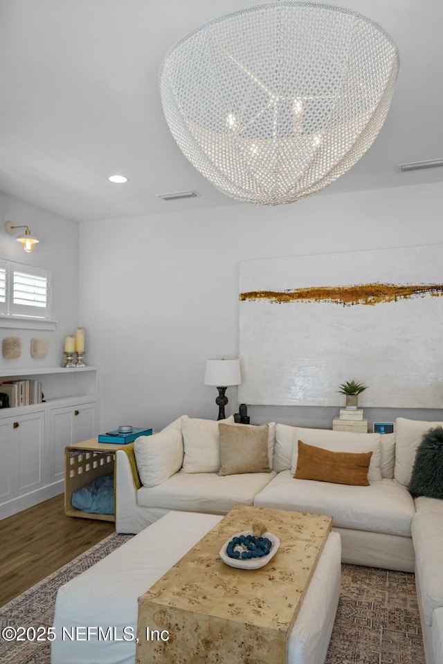 living room featuring a chandelier and dark wood-type flooring