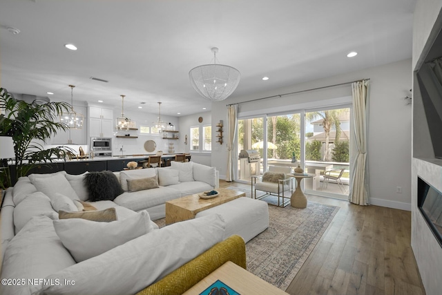 living room featuring a chandelier and light hardwood / wood-style flooring