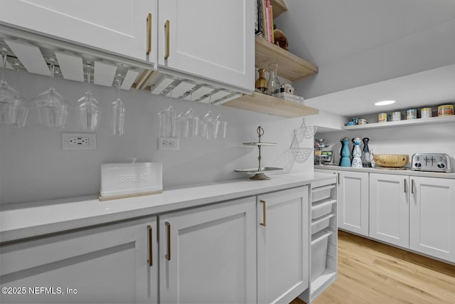 bar featuring white cabinetry and light wood-type flooring