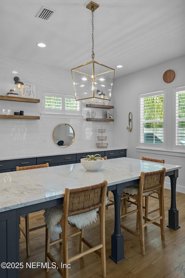 dining area featuring wood-type flooring and a chandelier