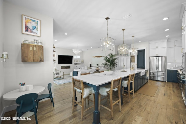 dining area with a chandelier, light hardwood / wood-style floors, and sink