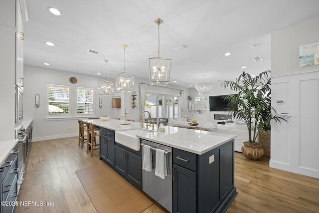 kitchen with a kitchen island with sink, white cabinetry, sink, and stainless steel dishwasher