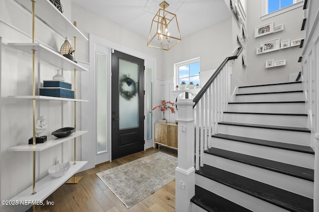 entrance foyer with hardwood / wood-style floors and a notable chandelier