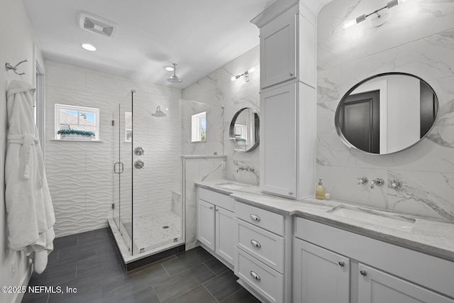 bathroom featuring tile patterned floors, tile walls, vanity, and an enclosed shower