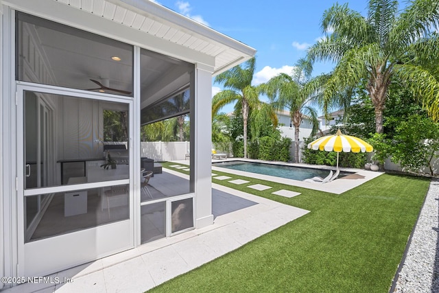 view of swimming pool with a patio, a lawn, and a sunroom