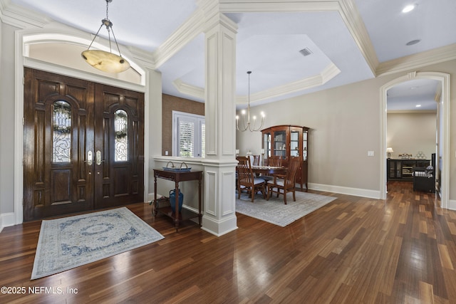 foyer entrance with dark hardwood / wood-style floors, crown molding, and a notable chandelier