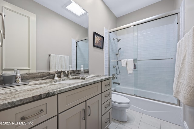 full bathroom with tile patterned floors, vanity, toilet, and shower / bath combination with glass door