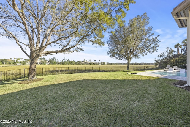 view of yard featuring a rural view, a patio, and a fenced in pool