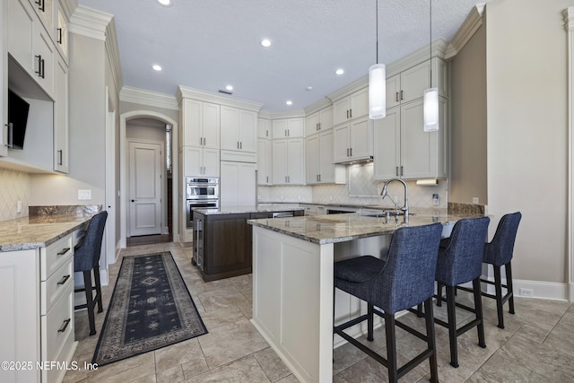 kitchen featuring a breakfast bar area, kitchen peninsula, sink, and decorative light fixtures