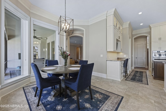 dining room featuring ceiling fan with notable chandelier and crown molding