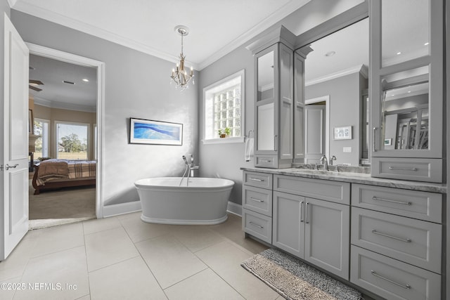 bathroom featuring a tub, a notable chandelier, tile patterned floors, crown molding, and vanity