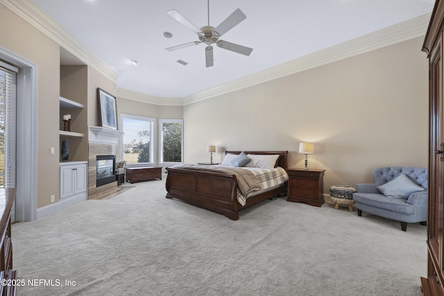 bedroom featuring a tiled fireplace, ceiling fan, light carpet, and ornamental molding