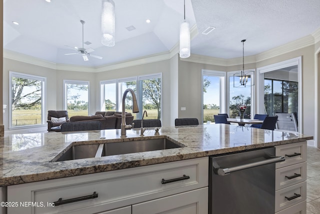 kitchen featuring light stone counters, white cabinetry, and hanging light fixtures