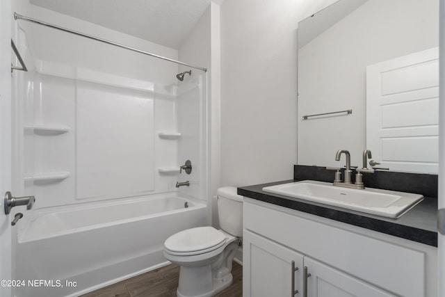 full bathroom featuring wood-type flooring, vanity, washtub / shower combination, and toilet