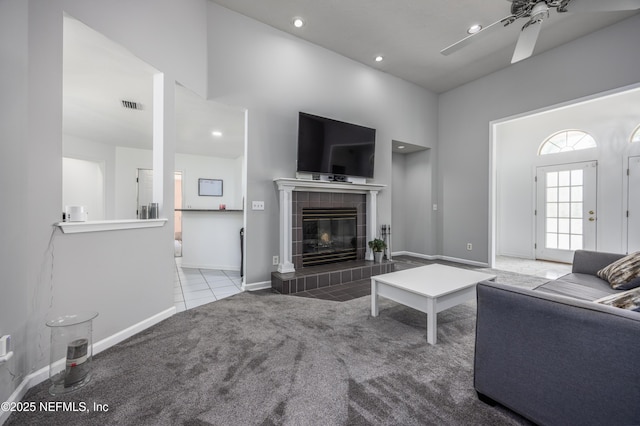 carpeted living room with a fireplace and ceiling fan