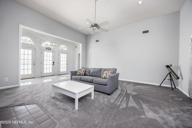 carpeted living room with a high ceiling and ceiling fan