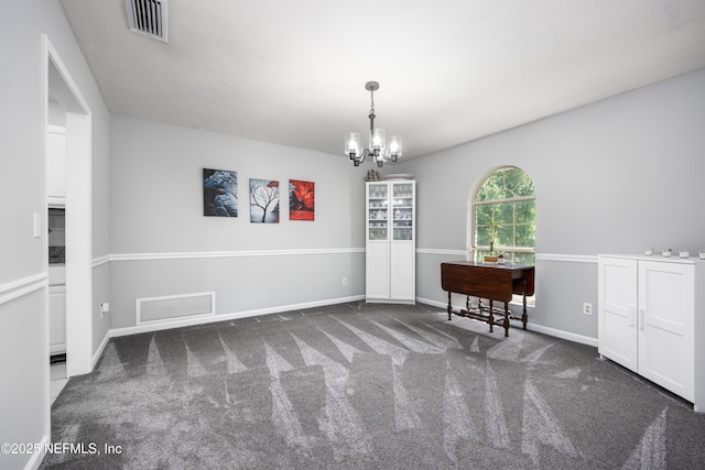 interior space featuring dark carpet and a chandelier