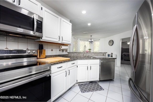 kitchen with backsplash, sink, white cabinets, and stainless steel appliances