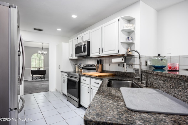 kitchen featuring light carpet, appliances with stainless steel finishes, sink, an inviting chandelier, and white cabinets