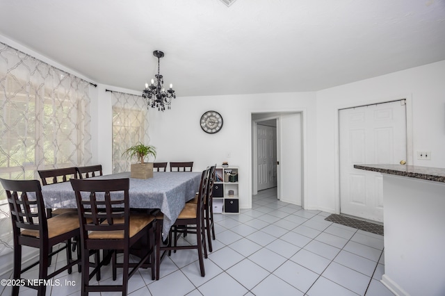 tiled dining area with a chandelier