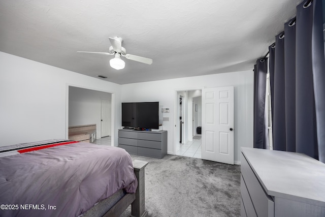 bedroom featuring light carpet, a textured ceiling, and ceiling fan