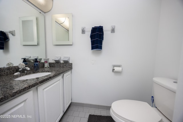 bathroom with toilet, vanity, and tile patterned floors