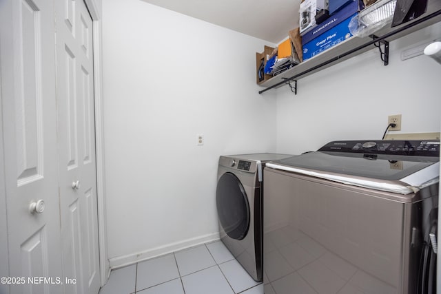 laundry area with washer and clothes dryer and light tile patterned flooring