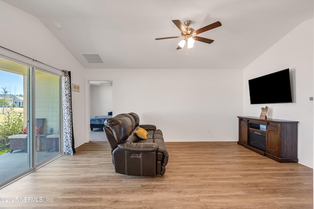 living area with lofted ceiling, light hardwood / wood-style flooring, and ceiling fan