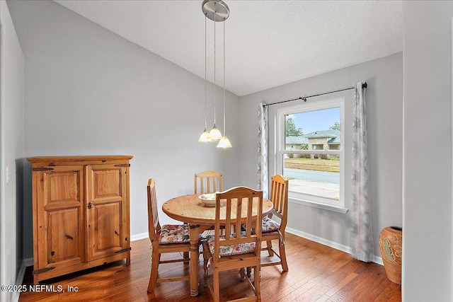 dining space with hardwood / wood-style flooring and a textured ceiling