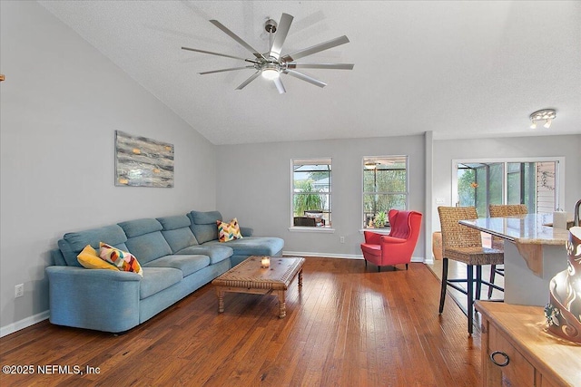 living room with a textured ceiling, ceiling fan, and dark hardwood / wood-style flooring