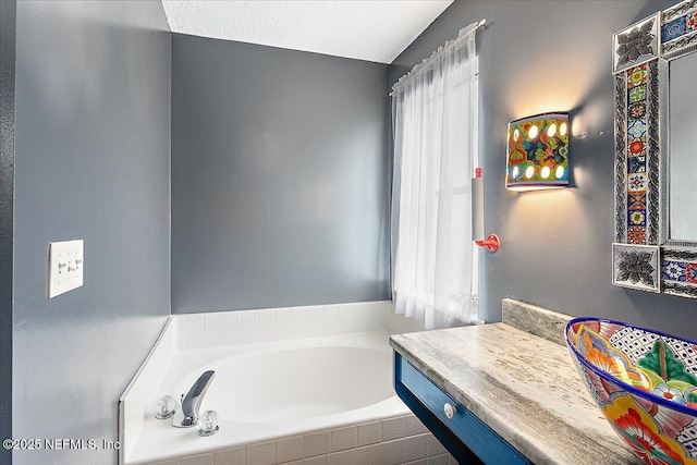 bathroom with a bathtub, a healthy amount of sunlight, and vanity